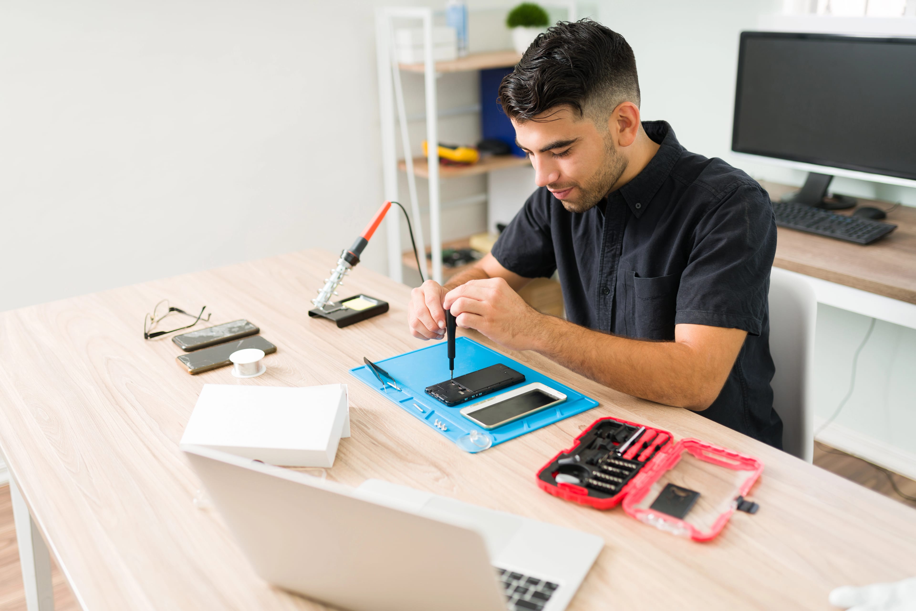 Técnico de Team Celular trabajando sobre un smartphone